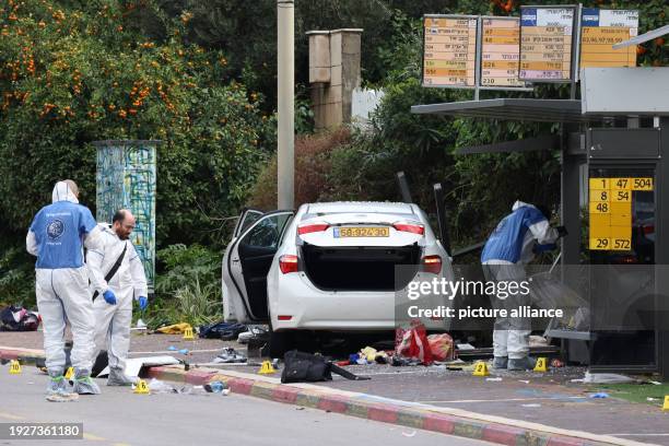 January 2024, Israel, Ra'anana: Israeli emergency personnel work next to a damaged car following a ramming attack in Ra'anana. An Israeli woman was...