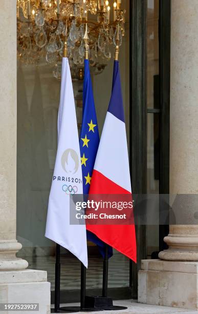 The flag of the Paris 2024 Olympic Games is seen near the French national flag and the European flag at the entrance of the Elysee Palace during the...