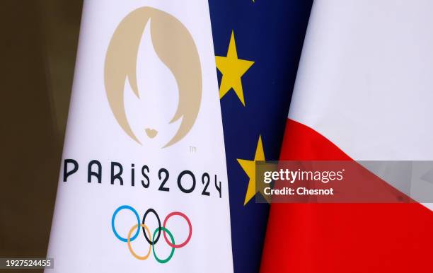 The flag of the Paris 2024 Olympic Games is seen near the French national flag and the European flag at the entrance of the Elysee Palace during the...