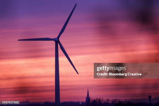 a wind turbine against a dramatic sky - windmill silhouette stock pictures, royalty-free photos & images