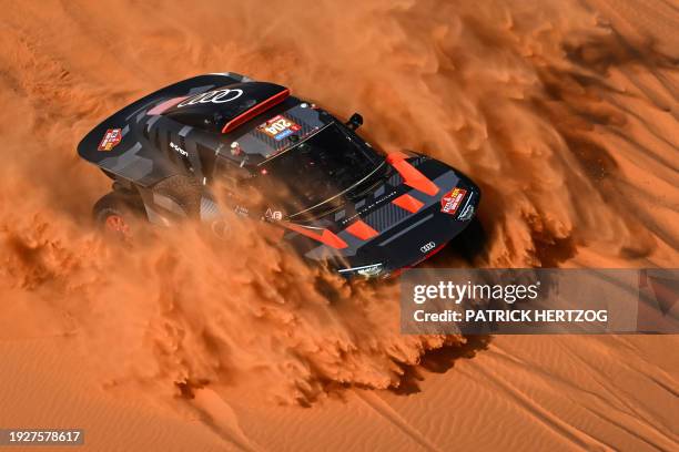 Team Audi Sport's Spanish driver Carlos Sainz and his Spanish co-driver Lucas Cruz steer their car in the dunes during the stage 8 of the 2024 Dakar...