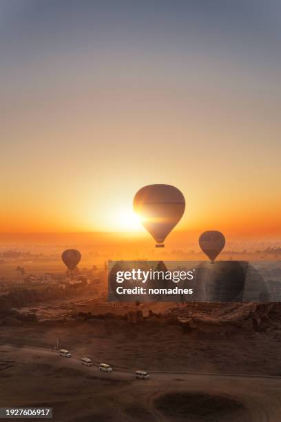 hot air balloon flying over medinet habu temple. stunning aerial view above temple of ramesses iii or the temple of amun. - hot air ballon foto e immagini stock