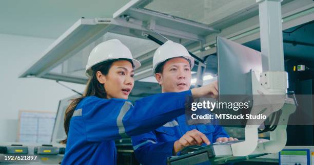 professional asian male and female industrial engineers operating machine keypad in manufacturing factory. working in manufacturing plant or production plant concept. - computer printing stock pictures, royalty-free photos & images
