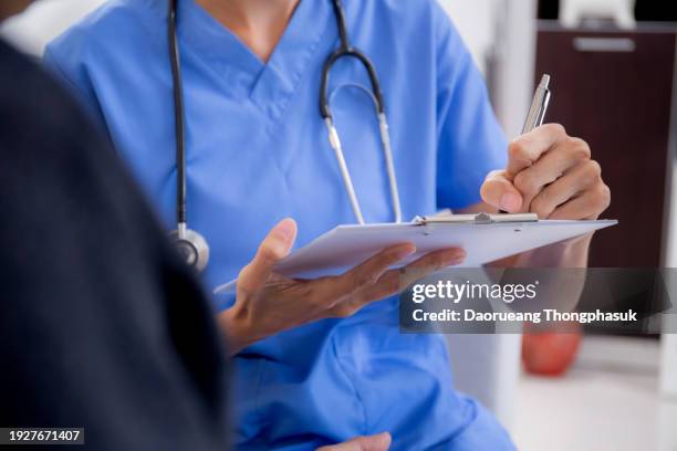 caregiver sitting on sofa checkup and diagnostic with elderly woman patient about health in living room at home, caretaker sitting on couch explaining and examining senior, insurance and medical. - clipboard stock pictures, royalty-free photos & images
