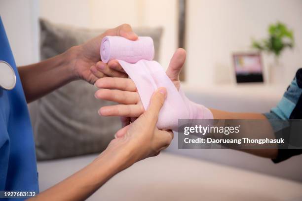 doctor or nurse care patient senior woman with injury on hand while putting the bandage in living room at home, caregiver and emergency, elderly and treatment, medical and insurance concept. - healing wound stock pictures, royalty-free photos & images