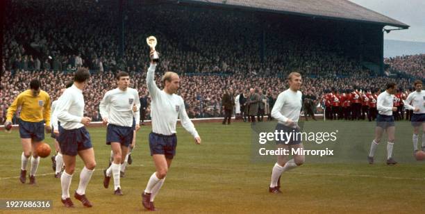 Bobby Charlton holds the Jules Rimet World Cup trophy up to the crowd after England beat Northern Ireland 2-0 in an International at Windsor Park,...