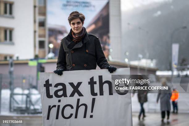 Austrian Marlene Engelhorn, who inherited from her family who owns the Germany's chemical giant BASF, poses with a placard reading "Tax the rich!" at...