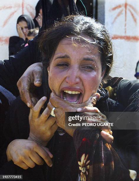 The wife of Palestinian Osama al-Sneiri mourns the death of her husband in Deir al-Balah in the Gaza Strip 27 November 2003. Al-Sneiri was killed by...