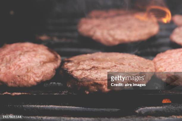 close up of fork kitchen utensil for flipping hamburger meat preparing on grill weekend social event - glowing hot steel stock pictures, royalty-free photos & images
