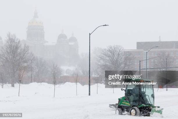 Snow plow clears snow from a road near the Iowa State Capitol on January 12, 2024 in Des Moines, Iowa. The second winter weather system in a week is...