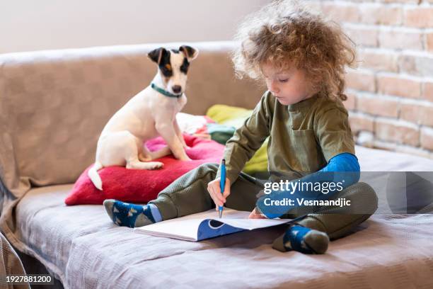 kleiner junge mit gips zu hause - gebrochener arm stock-fotos und bilder