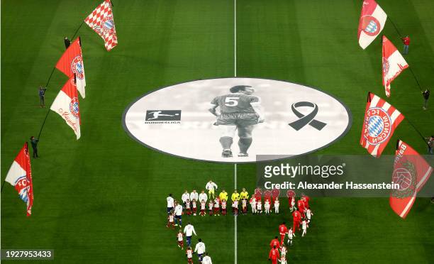 The players of both teams take to the field as a memorial banner is displayed in the centre of the pitch after the passing of former German football...