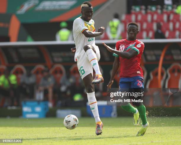 Pape Gueye of Senegal sees his shot blocked by Yankuba Minteh of Gambia during the TotalEnergies CAF Africa Cup of Nations group stage match between...