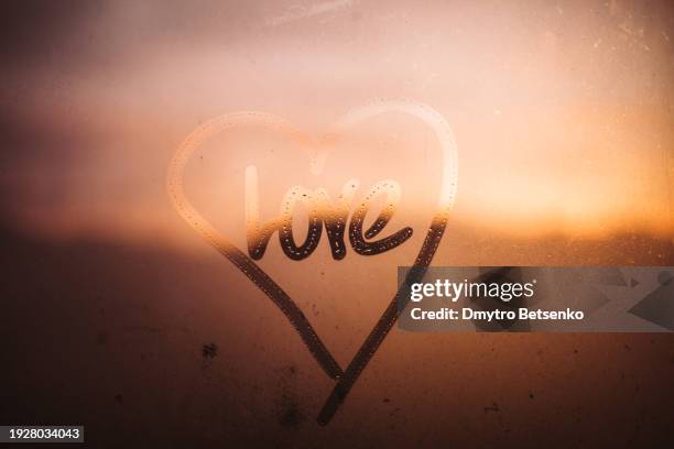 heart shape drawn on the window with word love written inside of it - condensation drawing stock pictures, royalty-free photos & images