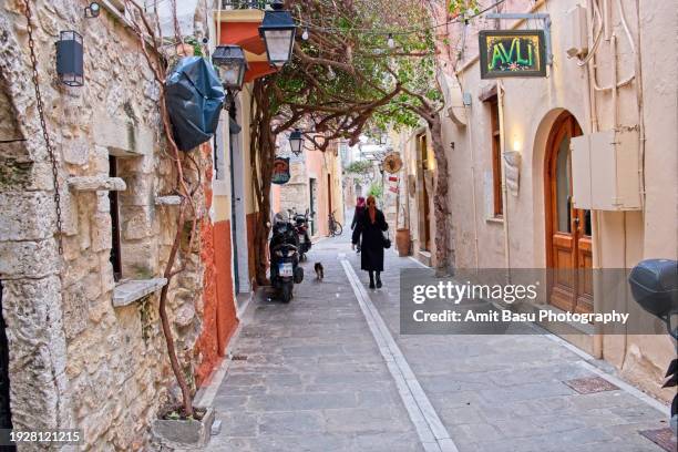 two woman tourists are seen walking  the narrow streets of old town rethymnon, crete - rethymnon town stock-fotos und bilder