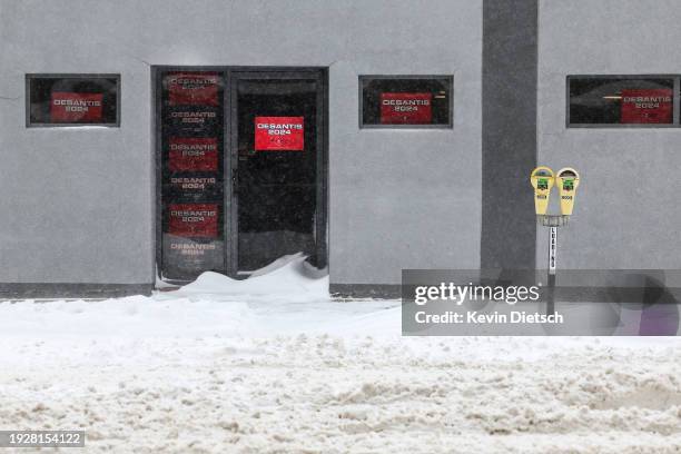 Signs are seen on the local campaign headquarters for Republican presidential candidate Ron DeSantis as heavy snow continues to fall on January 12,...