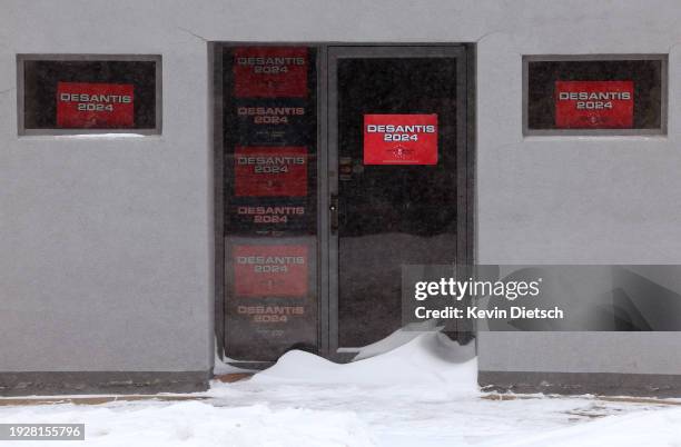Signs are seen on the local campaign headquarters for Republican presidential candidate Ron DeSantis as heavy snow continues to fall on January 12,...