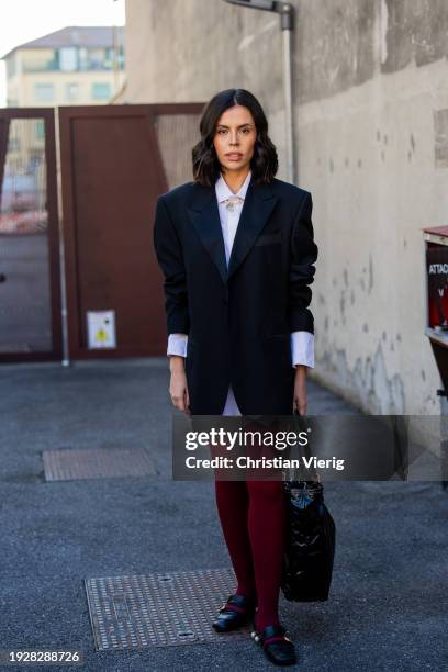 Guest wears black blazer, red tights, black bag, white button shirt, loafers outside Gucci during the Milan Fashion Week - Menswear Fall/Winter...