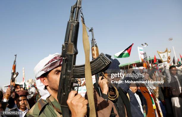 Yemenis lift rifles, Palestinian-Yemeni flags, and Houthi group emblems and shout slogans while protesting against violating Yemen's sovereignty...