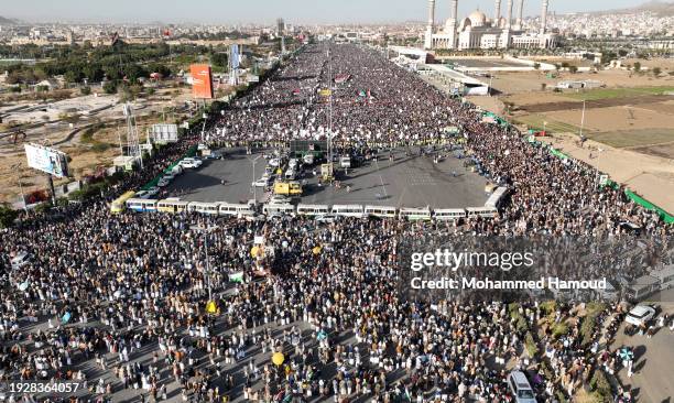 An aerial view shows Yemenis lift Palestinian-Yemeni flags, and Houthi group emblems while protesting against violating Yemen's sovereignty through...