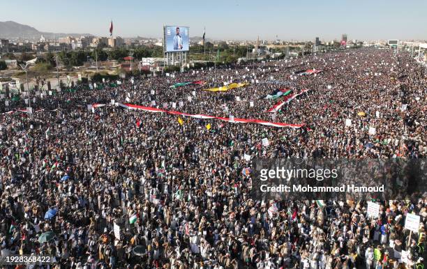An aerial view shows Yemenis lift Palestinian-Yemeni flags, and Houthi group emblems while protesting against violating Yemen's sovereignty through...