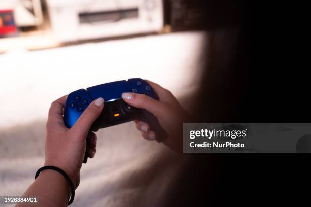 Person is holding a Sony DualSense wireless gaming controller in galactic purple.