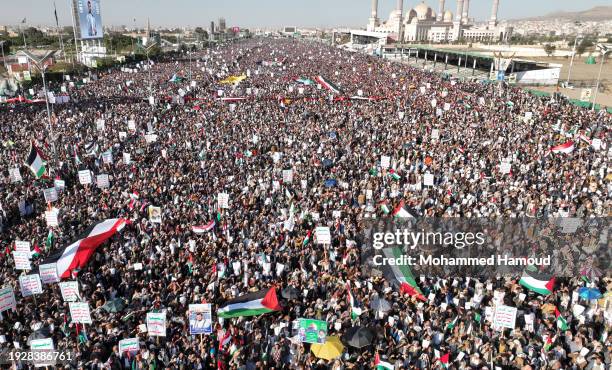 An aerial view shows Yemenis lift Palestinian-Yemeni flags, and Houthi group emblems while protesting against violating Yemen's sovereignty through...