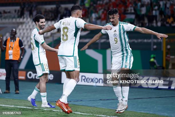 Algeria's forward Baghdad Bounedjah celebrates with teammates afer scoring his team's first goal during the Africa Cup of Nations 2024 group D...