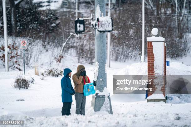 Pedestrians wait to cross the street during a winter storm on the day of the Iowa Caucus in Des Moines, Iowa, US, on Monday, Jan. 15, 2024. Iowa...