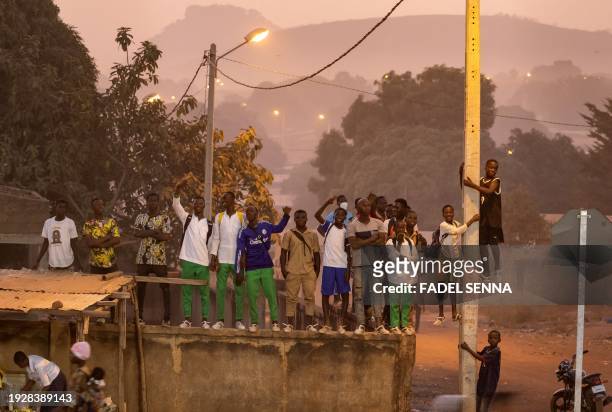 People watch from a street Mali's training session at the Dominique Ouattara secondary school in Korhogo on January 15 on the eve of the 2024 Africa...