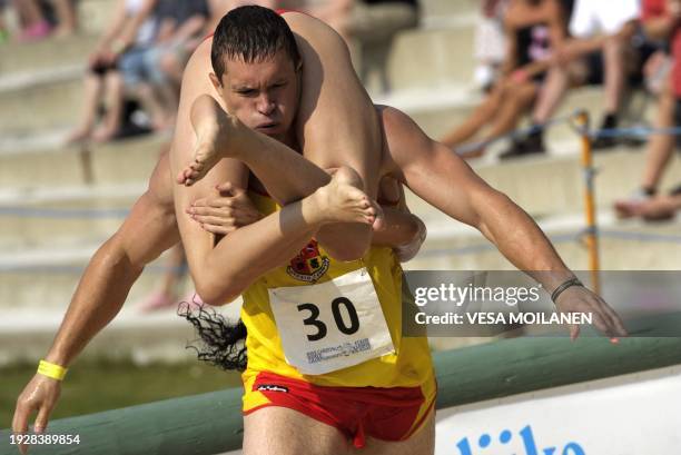 Lithuanian Vytautas Kirkliauskas runs with his wife Neringa Kirkliauskiene on July 2, 2011 during the Wife Carrying World Championship competition in...