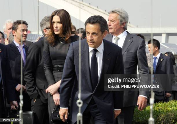 France's President Nicolas Sarkozy , his wife Carla Bruni-Sarkozy and French actor Alain Delon walk in the French pavilion, during a visit at the...