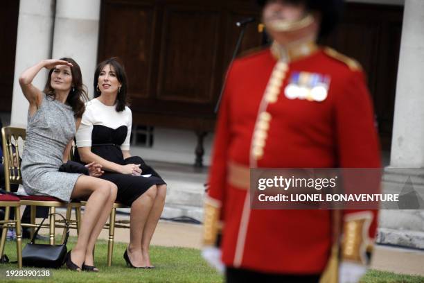 French first lady Carla Bruni-Sarkozy sits near British Prime Minister's wife Samantha Cameron at the royal Chelsea Hospital in London on June 18,...