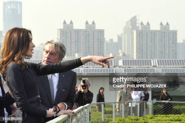 French first lady Carla Bruni-Sarkozy , speaks with French actor Alain Delon as they walk in the French pavilion, during a visit at the Shanghai...