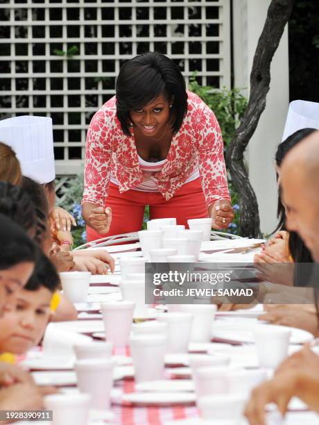 First Lady Michelle Obama shouts "we want food, we want food" as she sits down with some of 36 fifth grade students to eat a meal prepared with...