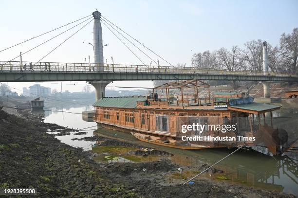 Houseboat is seen on the banks of Jhelum river on January 15, 2024 in Srinagar, India. Water level in Jhelum hits lowest as dry spell continues.