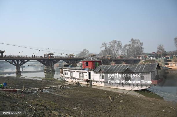 Houseboat is seen on the banks of Jhelum river on January 15, 2024 in Srinagar, India. Water level in Jhelum hits lowest as dry spell continues.