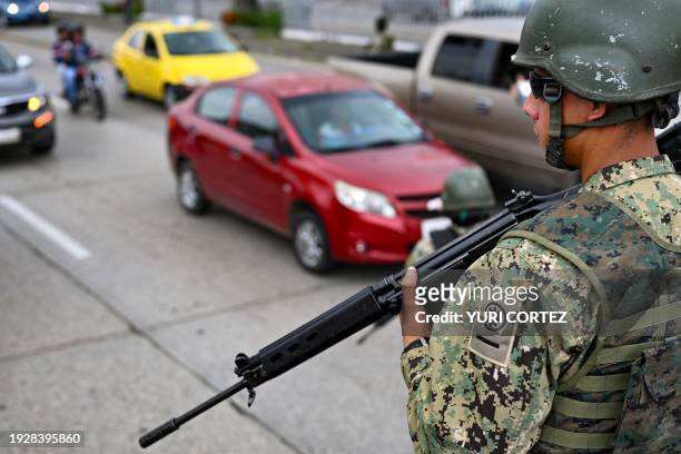 Soldier holds a Belgian-made FAL 7.62mm caliber rifle while standing guard at a checkpoint during a joint operation between the Ecuadorean National...
