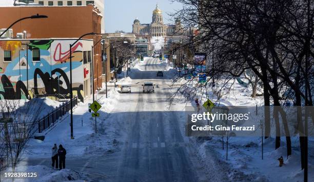Two pedestrians brave the sub-zero temperatures downtown as extreme temperatures and snow have gripped Iowa during Iowa Caucus week on January 14,...