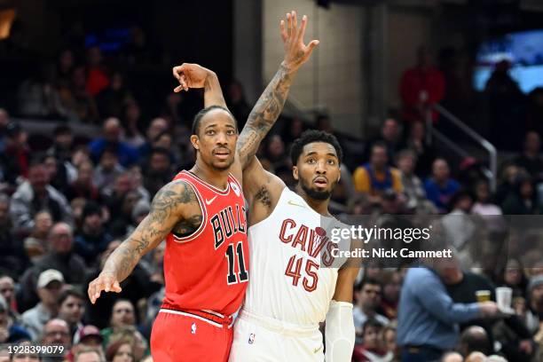 Donovan Mitchell of the Cleveland Cavaliers and DeMar DeRozan of the Chicago Bulls watch a shot by Mitchell during the first half at Rocket Mortgage...