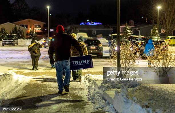 Caucus goer leaves with a Trump sign after Trump won the Iowa Caucuses in this precinct by nine votes at Mitchell Elementary January 15, 2024 in...