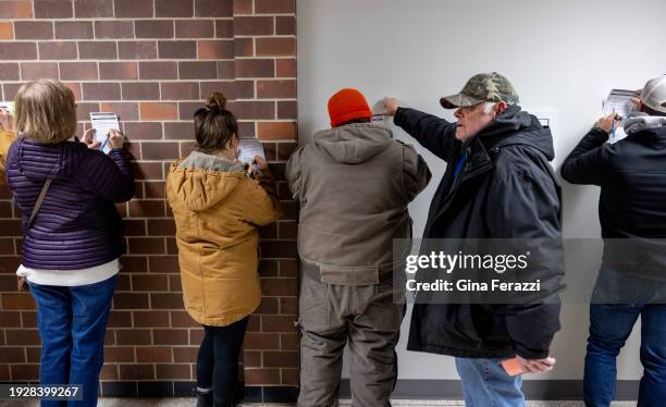 Iowans use the wall to fill out their registration paperwork on Caucuses night at Mitchell Elementary school on January 15, 2024 in Ames, Iowa.The...