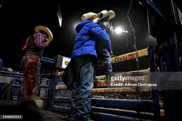 Saddle bronc rider Marcus Verser Sr. Holds his son, Marcus Jr., for a better vantage point of the action during the MLK Jr. African-American Heritage...