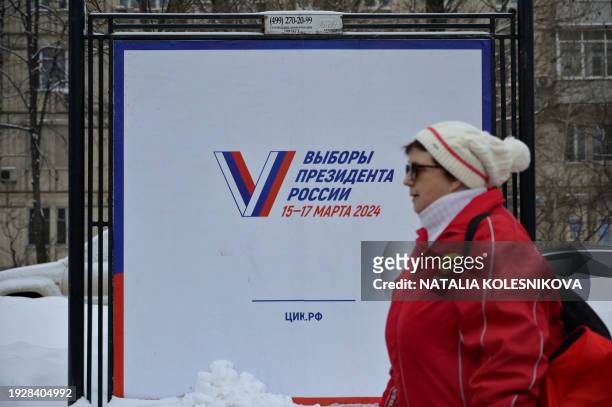 Woman passes by a poster announcing the 2024 presidential election in Moscow on January 16, 2024. The election will be held over a three-day period...