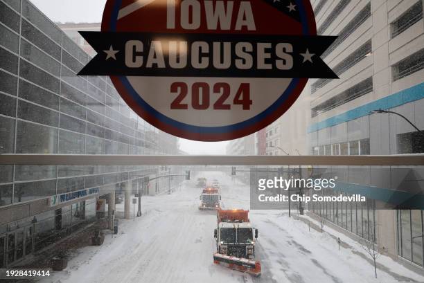 Plow trucks clear Grand Avenue as high winds and snow from winter storm Gerri four days before the Iowa caucuses on January 12, 2024 in Des Moines,...