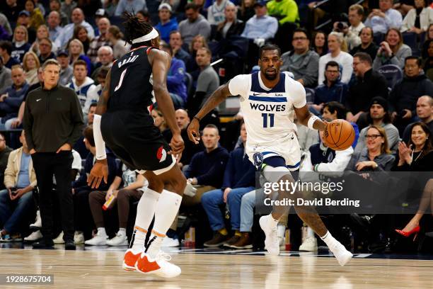 Naz Reid of the Minnesota Timberwolves dribbles the ball to the basket while Jerami Grant of the Portland Trail Blazers defends in the second quarter...