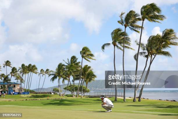 Carl Yuan of China lines up a putt on the 17th green during the second round of the Sony Open in Hawaii at Waialae Country Club on January 12, 2024...