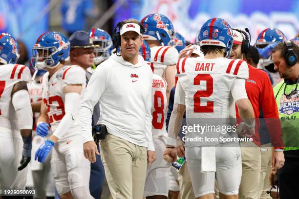 Mississippi Rebels head coach Lane Kiffin greets quarterback Jaxson Dart on the sideline during the Chick-fil-A Peach Bowl against the Penn State...