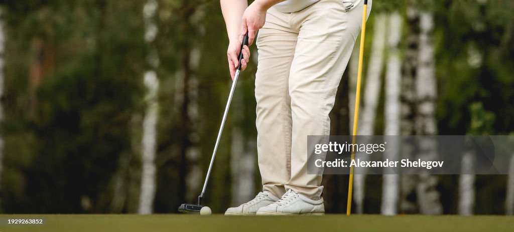 Close-up photo of playing golf in the professional club outdoors with sports equipment on the green grass with the ball.