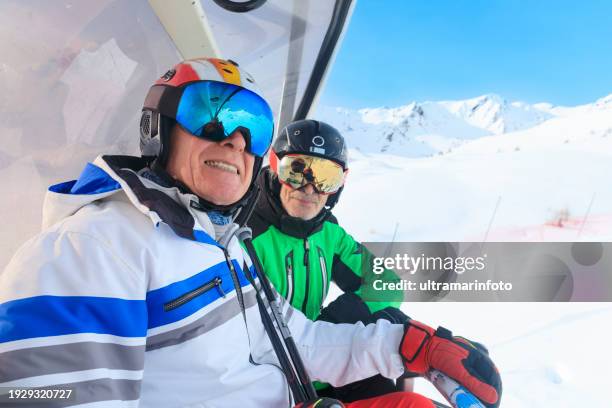 active lifestyle, portrait vital happy senior, two men best friends. snow skier, enjoying on ski lift, sunny ski resorts. snowcapped mountain dolomite super ski area. ski resort italy, europe. - ski lift stock pictures, royalty-free photos & images